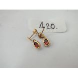 A pair of stone set ear pendants set in gold