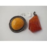 A circular amber brooch & an amber pendant