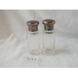 A pair of silver mounted scent bottles with glass bodies - 2.5" high - London 1915