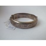A floral engraved wide silver bangle