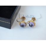 A pair of screw on earrings with amethyst stones in 9ct
