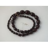 A antique string of dark red amber beads