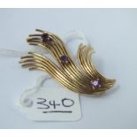 A fancy brooch set with 3 purple stones in 14ct gold - 7.2gms