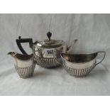 An half-fluted boat shaped tea set on rim foot. The teapot - London 1900, sugar and cream