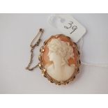 An oval cameo brooch in a fancy twist frame set in 9 ct - 9.7gms