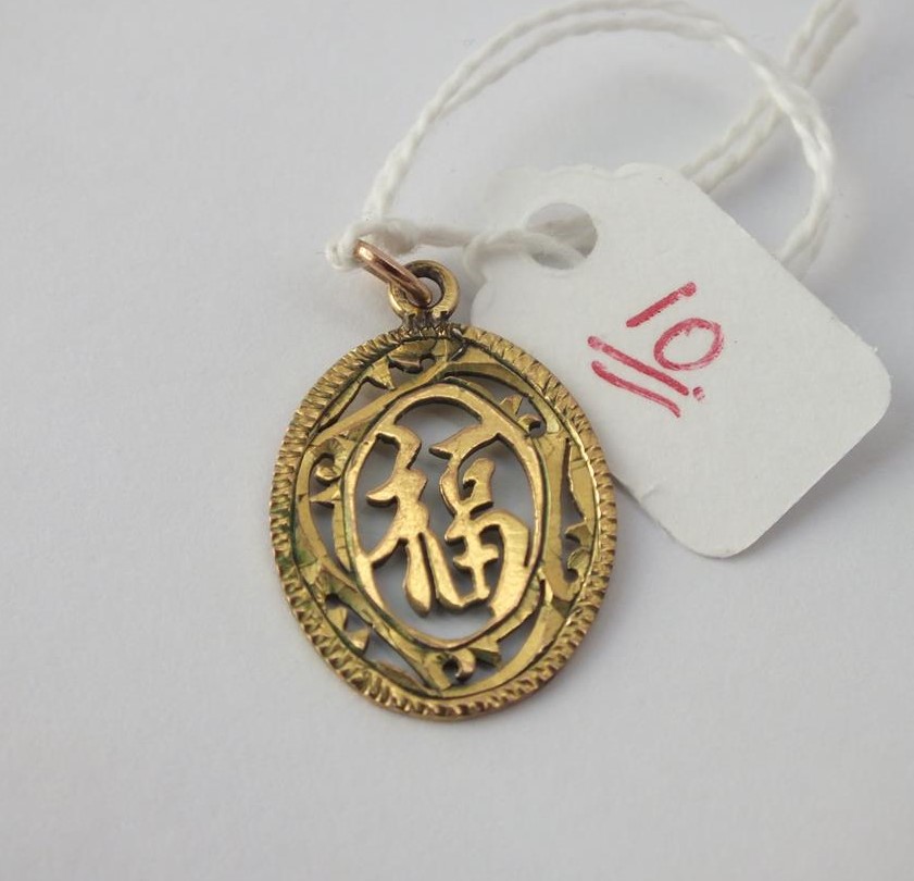 An oval Chinese pendant in 18 ct gold - 1.7gms