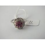 A white gold ruby cluster ring in 18 ct gold - Size N - 3.4gms.