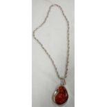 A RECONSTITUATED AMBER PENDANT ON SILVER CHAIN