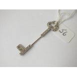 A diamond key shaped pin with initial E in white gold