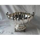 A STYLISH SOLID STERLING SIVLER BOWL WITH RIBBED BODY AND FOUR SCROLL FEET - 10" over handles -