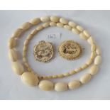 Two carved bone brooches & large bone bead necklace