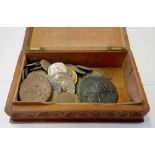 A wooden box of old coins