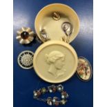 EMBOSSED HARD PLASTIC ROUND TRINKET CONTAINER WITH MISC BROOCHES