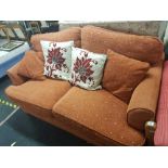 AN ORANGE 2 SEATER BED SETTEE