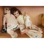 3 GERMAN PORCELAIN HEADED DOLLS IN ORIGINAL CLOTHING (DOLL HAS LEG MISSING)