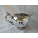A Dutch cream jug with beaded rims and scroll handle - 149 gms.