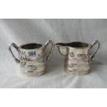 A good quality Chinese silver (900 standard) sugar and cream jug decorated with bamboo foliage and