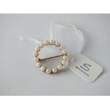 A circular pearl brooch set in 9ct