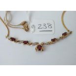 A garnet and diamond necklace in 9ct - 5.8gms