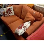 AN ORANGE 2 SEATER BED SETTEE