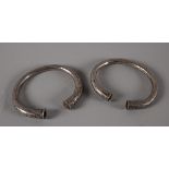 A pair of silver torc bangles Of Asian origin, decorated with dots and X's, 280g, 3 in. diameter.