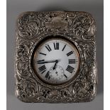 An Edwardian Goliath watch, or travel clock Nickel case, open face, white enamel dial in outer