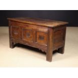 A 17th Century Oak Coffer having a planked lid above a triple panel facade;