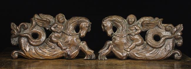 A Pair of 17th Century Pierced & Carved Oak Panels depicting winged cherubs riding on the backs of