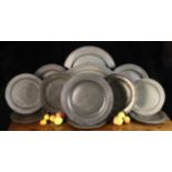 A Collection of Eleven Antique Pewter Chargers ranging in size from 56 cm to 34 cm in diameter (22"