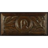 A Carved Oak 'Romayne' Panel depicting a profile portrait head of a 16th century lady flanked by