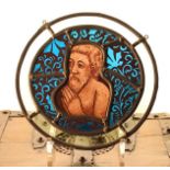 A Stained & Leaded Glass Tondo depicting a bust of a man with hands held in prayer,