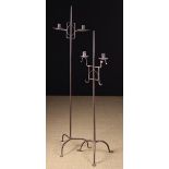 Two Similar Wrought Iron Floor Standard twin-socket Candle Holders; one 18th century,