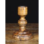 An 18th Century French Turned Treen Candlestick with ringed bulbous stem on a round moulded foot,