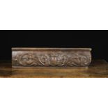 A 17th Century Oak Bulge Front Frieze Panel carved in relief with undulant scrolls of foliage