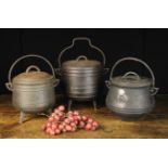 Three Small Cast Iron Lidded Cauldrons; two raised on three legs;