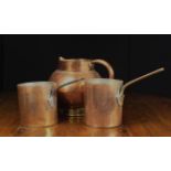 A Large Early 19th Century Brass Footed Sheet Copper Jug with bulbous body and tubular handle,