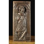 A Late 16th Century Panel carved with a female figure holding a pair of callipers,