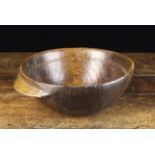A Dug-out Treen Bowl with ring turned interior and a lip handle to one side, 9 cm high,