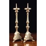 A Pair of 18th Century Bronze Pricket Candlesticks with knopped stems and scrolling triform bases