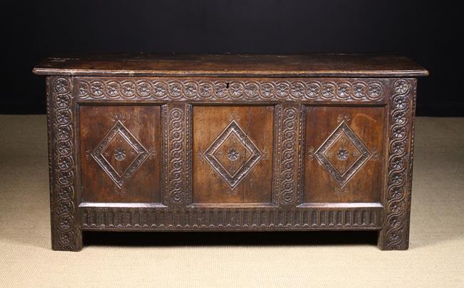 A Charles I Oak Coffer. The twin plank lid with chip carved ends.