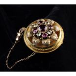 A Victorian Brooch set with a ruby surrounded by oval amethysts and diamonds fitted with a safety