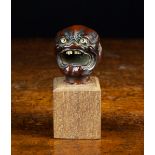 A 19th Century Japanese Carved Boxwood Head depicted screaming with inset glass eyes and jagged