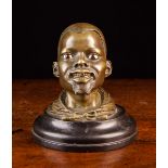 A 19th Century Bronze Inkwell cast in the form of an African man's head with glass inset eyes,