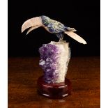 A Carved Nephrite Jade & Rose Quartz Toucan perched upon an amethyst cluster mounted in an oval