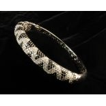 An 18 Carat White Gold & Diamond Bangle.