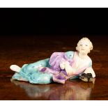 A Rare Meissen Porcelain Reclining Figure of a man in blue gown holding slippers,