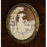 A Victorian Carved Shell Cameo Brooch finely carved with a shepherdess in landscape.