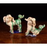 A Pair of Chinese Sancai Glazed Dogs-of-Fo: One depicted standing, the other seated,