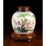 A Chinese 'Famille Verte' Ginger Jar with turned wooden cover and decorative carved stand.