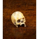 An Antique Carved Bone Momento Mori in the form of a skull, 1¼" (3 cm) in height.
